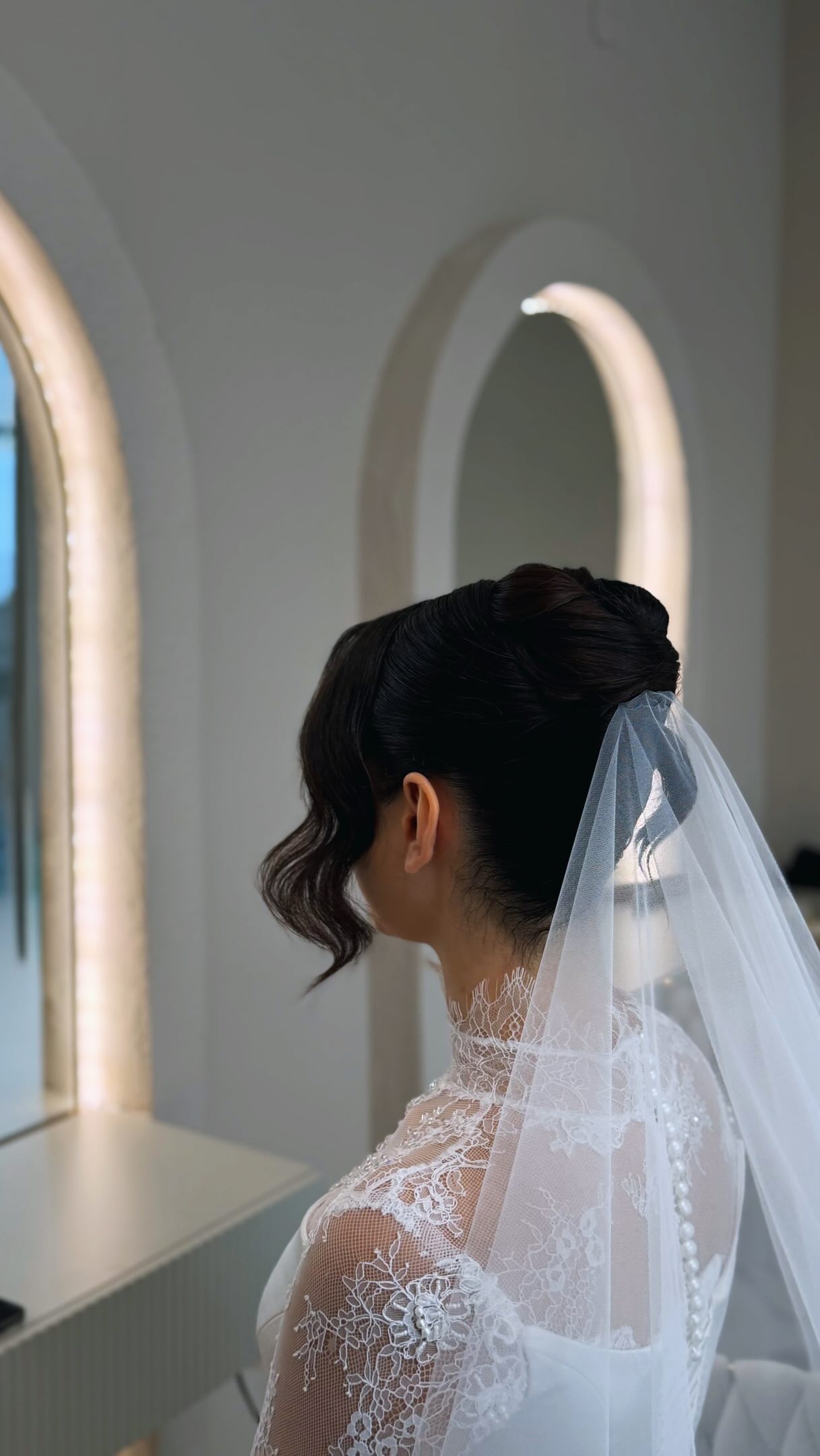 Braut mit eleganter Hochsteckfrisur und Schleier, gestylt im DS Studio